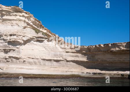 Falaises de craie spectaculaires et côte calcaire accidentée de la péninsule de Delimara à la pointe sud-est de Malte, photographiées depuis la mer sur un soleil Banque D'Images