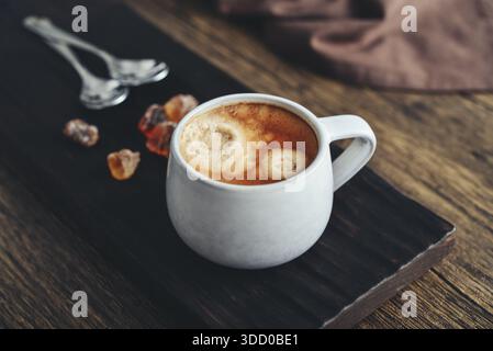 Deux tasses de café sur un plateau en bois avec du sucre de canne à roche en gros plan Banque D'Images
