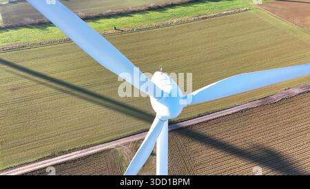 La turbine éolienne aérienne projette de l'ombre sur les champs agricoles Banque D'Images