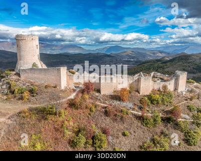 Vue aérienne du château de Bominaco en Italie avec donjon circulaire sur une colline spectaculaire, ciel nuageux bleu Banque D'Images