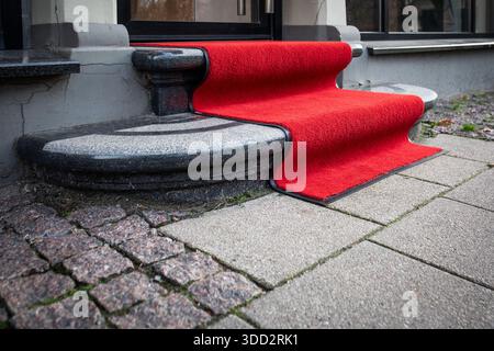 Tapis rouge sur les marches d'entrée en pierre de l'extérieur du bâtiment. Banque D'Images