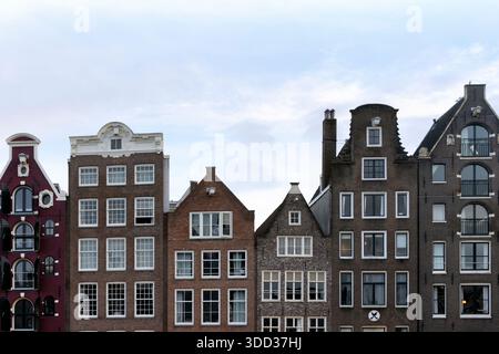 Maisons colorées en bord de mer du canal Damrak, façades hollandaises classiques, destination de voyage célèbre. Pour les guides touristiques, les visuels de blog de voyage et les médias sociaux po Banque D'Images