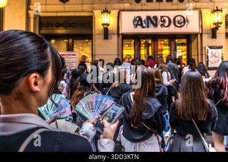 Femme tenant des billets et un smartphone avant un concert ANDO à Osaka, préfecture d'Osaka, Japon Banque D'Images