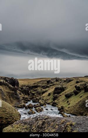 Rivière Skógá sous un ciel orageux. Long fleuve traverse les Highlands de l'Islande, tempête estivale, changement climatique. Création de la célèbre cascade de Skógafoss Banque D'Images