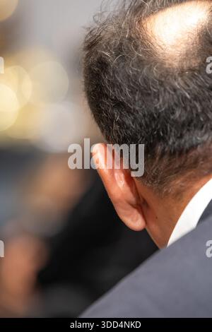 Gros plan d'un homme en costume - vue arrière montrant une tache chauve bien visible Banque D'Images