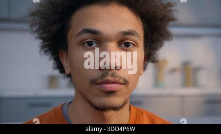 Calme homme afro-américain sérieux regardant l'appareil photo gros plan portrait à la maison propriétaire homme locataire posant à l'intérieur appartement tête de l'ethnie jeune Banque D'Images