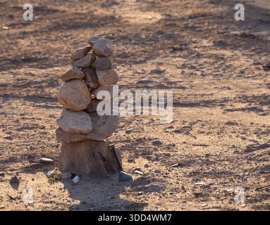 L'homme a fait pile de rochers équilibrés les uns sur les autres pour faire un inukshuk ou statue d'installation d'art de sortes dans un champ très sec dans l'espace du nouveau Mexique sur Banque D'Images