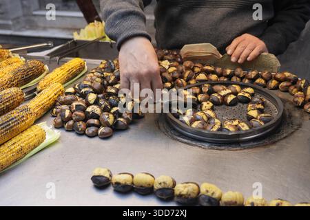 Vendeur cuisine des châtaignes et du maïs dans la rue par temps froid à Istanbul Banque D'Images