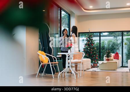 Femmes conversant dans le hall moderne festif se préparant pour la célébration de noël Banque D'Images