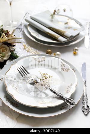 Cadre élégant et festif, parfait pour la table de Noël, avec des couleurs blanc, or et gris argenté. Décorations de Noël avec des boules, bougie. Banque D'Images
