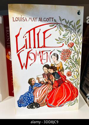 Londres, Royaume-Uni - 12 décembre 2025 : couverture vintage mettant en vedette quatre sœurs lisant ensemble parmi des vignes florales. Little Women de Louisa May Alcott Banque D'Images