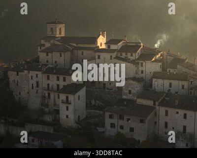 Vue aérienne des bâtiments anciens se prélasser dans la lumière dorée du crépuscule, avec la tour de l'église perçant la ligne d'horizon de Casteldilago, Casteldilago, Ombrie Banque D'Images