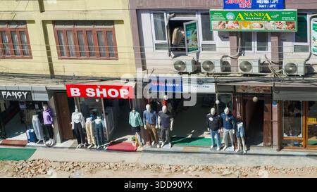 Vue sur la rue des magasins présentant des mannequins habillés de vêtements à la mode, présentant une scène urbaine animée du commerce de détail. Banque D'Images