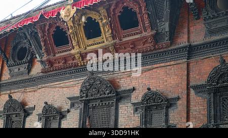 Bâtiment avec fenêtres traditionnelles et boiseries ornées à la maison Kumari. Banque D'Images