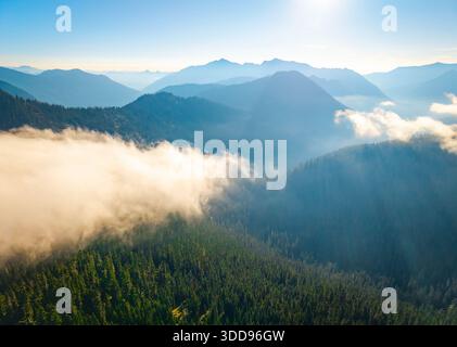 Une vue aérienne panoramique époustouflante mettant en valeur le vaste Mt. Baker-Snoqualmie National Forest, avec ses paysages luxuriants illuminés sous un ciel ensoleillé Banque D'Images