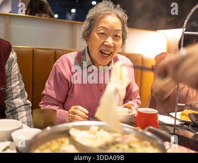 Les femmes âgées asiatiques grand-mère profite du dîner avec sa famille au restaurant. Banque D'Images