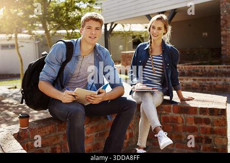 Étudiants universitaires, homme et apprentissage avec ordinateur portable en plein air pour des conseils d'étude, préparation aux examens ou aide. Formation, personnes et tuteur avec notes de cours à Banque D'Images
