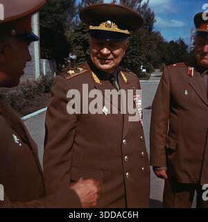 Slaviansk, région de Donetsk, RSS d'Ukraine, Union soviétique, années 1980 Une photographie d'archives en couleur montrant le maréchal des troupes blindées Oleg Losik, un citoyen d'honneur de la ville. Le commandant distingué est capturé souriant lors d'une conversation avec d'autres officiers dans un cadre extérieur. Il porte un uniforme de cérémonie avec des épaulettes dorées et une poitrine pleine de rubans de récompense. Un moment humain rare de l'élite militaire soviétique dans le Donbass pacifique Banque D'Images