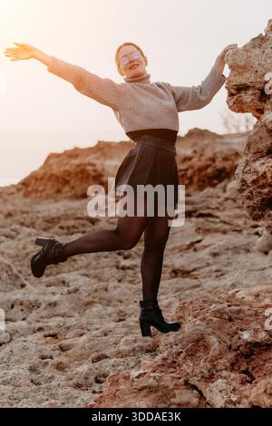 Femme Rocky Landscape Autumn Joyful pose : Shoot de mode en plein air, Happy expression, Sunset Rocks. Banque D'Images