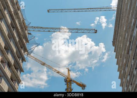 Une grue à tour près de gratte-ciel en construction. Affaires d'appartement Banque D'Images
