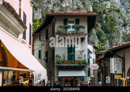 Limone sul Garda, Italie - 20 août 2025 : charmante scène de rue dans le village pittoresque de Limone Sul Garda, Italie, avec des bâtiments traditionnels et une végétation luxuriante. Banque D'Images