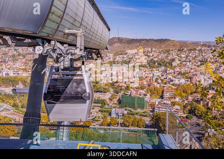 1er novembre 2025, Tbilissi, Géorgie : téléphérique montrant un paysage urbain panoramique de Tbilissi avec la cathédrale de la Sainte Trinité et les couleurs d'automne Banque D'Images