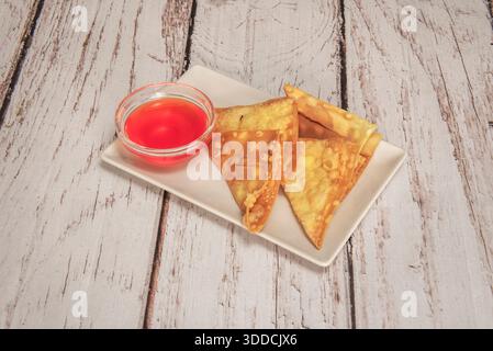 Wontons de style cantonais dans une soupe de nouilles avec des wontons de porc et de crevettes, accompagnés de tranches de poisson, d'algues nori et d'une tranche de narutomaki Banque D'Images