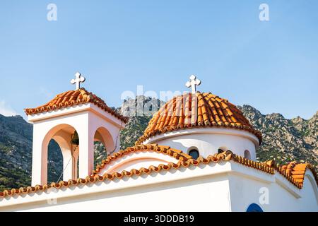 Saint Phanourios paraskevi église toit en gros plan de la religion orthodoxe grecque à Magganitis, Ikaria, Grèce longévité zone bleue au coucher du soleil avec des montagnes Banque D'Images