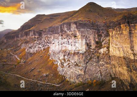 Ancien monastère de grottes de Vardzia dans le sud de la Géorgie creusé dans des falaises accidentées avec des centaines de grottes illuminées par la lumière du coucher du soleil Banque D'Images