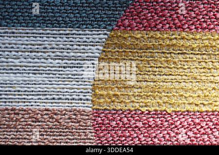 Vue rapprochée des carrés de tissu d'ameublement texturé. Gros plan à angle élevé de nuances de tissu d'ameublement texturé multicolore dans un motif de grille Banque D'Images