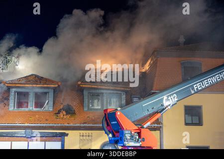 Lieferwagen brennt neben Gebäude Feuer greift auf Dachstuhl über am 31.12.2025 geriet kurz vor 02 :00 Uhr ein Lieferwagen in Brand, der direkt neben einem Gebäude mit Wohn- und Geschäftseinheiten in Bickenbach Stand. Die Flammen griffen auf den angrenzenden Dachstuhl über und breiteten sich auf dem Großteil des Dachbodens aus. Da dieser nicht von innen erreichbar War, mussten die Einsatzkräfte die gesamten Dachziegel entfernen, um gezielte Löschmaßnahmen durchführen zu können. Vier Drehleitern sowie ein Mast der Werkfeuerwehr Merck kamen zum Einsatz. Winterliche Minusgrade erschwerten die Lösc Banque D'Images