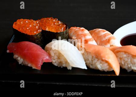 Sushi et rouleau de sushi sur la table en pierre noire. Cuisine asiatique traditionnelle, Tokyo, Japon. Banque D'Images