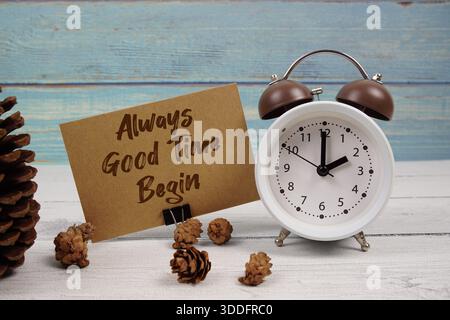 C'est toujours le bon moment pour commencer ! texte écrit sur carte papier avec réveil et décoration de pommes de pin sur fond de bois Banque D'Images