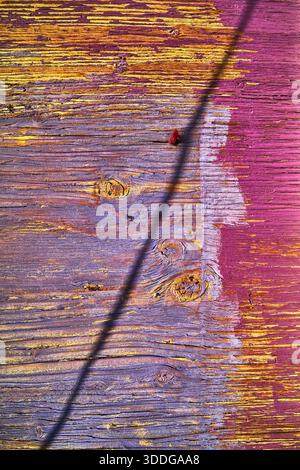 Texture colorée en bois vieilli avec peinture jaune et violette et ombre diagonale Banque D'Images