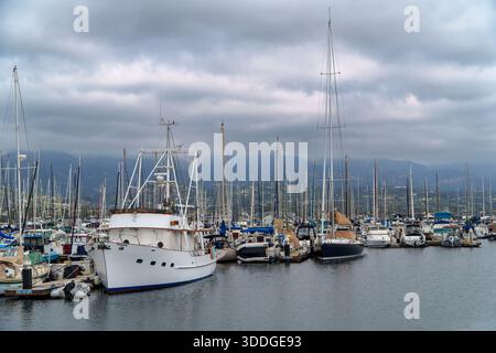 santa barbara, CA, États-Unis. 07 octobre 2025. - De nombreux bateaux, y compris des voiliers et yachts à moteur, sont amarrés dans une marina sous un ciel couvert, avec m Banque D'Images