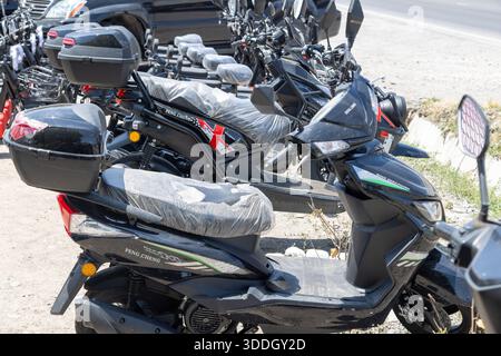 Plusieurs scooters électriques chinois abordables sont en vente dans les rues de Sokuluk, Kirghizistan - 23 juin 2024 Banque D'Images