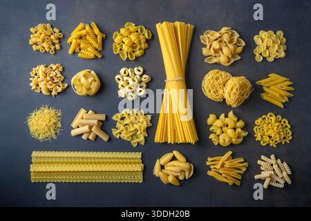 Composition avec différentes pâtes non cuites savoureuses - papier peint de pâtes italiennes, différents types et formes de mise en page des pâtes Banque D'Images