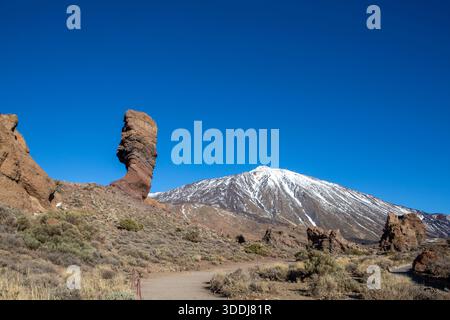 Vue sur Roques de Garcia, formation rocheuse unique avec le célèbre sommet du volcan de montagne Pico del Teide en arrière-plan par un matin ensoleillé. Banque D'Images