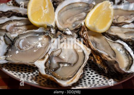 Huîtres fraîches sur le marché hebdomadaire français, nourriture de rue, portion d'huîtres ouvertes avec citron, fruits de mer, France, gros plan Banque D'Images