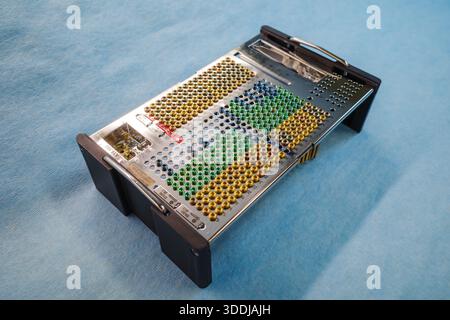 Photographie en studio haute résolution d'une vis chirurgicale et d'un plateau d'implant avec des vis médicales à code couleur disposées dans un organisateur métallique de précision sur un Banque D'Images