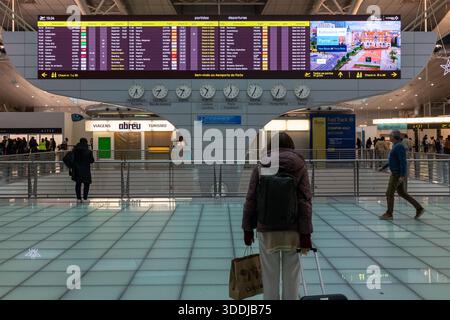 Un tableau numérique des départs indique les retards et les changements de porte d'embarquement pendant les perturbations nationales des voyages à l'aéroport de Porto. 01 janvier 2026 Banque D'Images