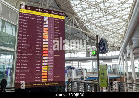 Un tableau numérique des départs montre les retards et les changements de porte pendant les perturbations de voyage à l'aéroport de Porto le 1er janvier 2026. Banque D'Images