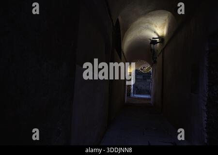 Arche étroite menant à un porche avec des lumières suspendues Banque D'Images