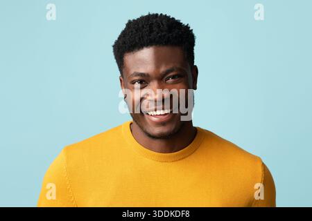 Portrait d'un beau gars afro-américain posant sur le bleu Banque D'Images