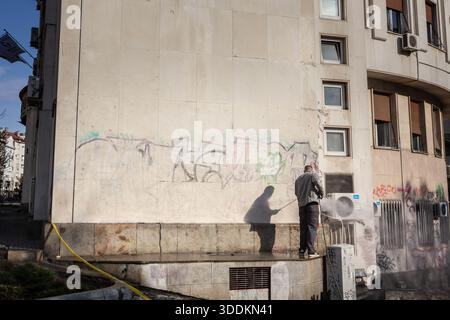 BELGRADE, SERBIE - 6 AVRIL 2019 : un homme enlève des graffitis d'un mur à Belgrade à l'aide de matériel de nettoyage, pour des travaux d'entretien urbain axés sur le restor Banque D'Images