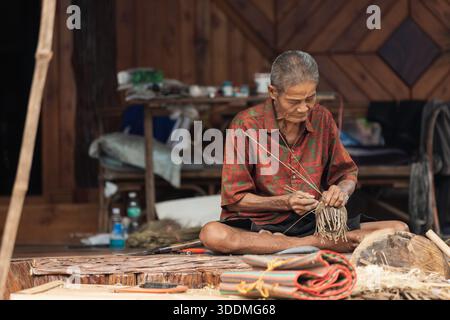 Vieux artisan thaïlandais tissant des paniers en bambou Banque D'Images