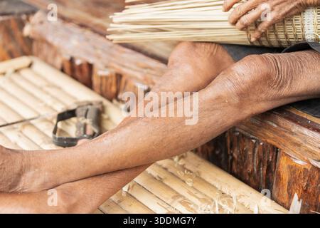 Gros plan de vieux artisans tissant des bandes de bambou Banque D'Images