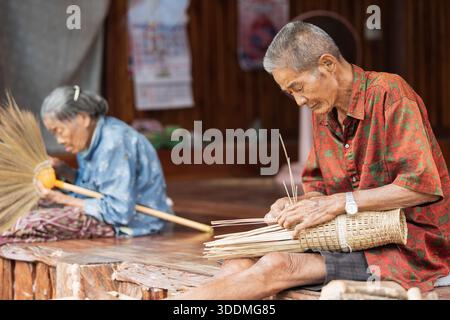 Fabrication traditionnelle de panier en bambou à la maison thaïlandaise rurale Banque D'Images