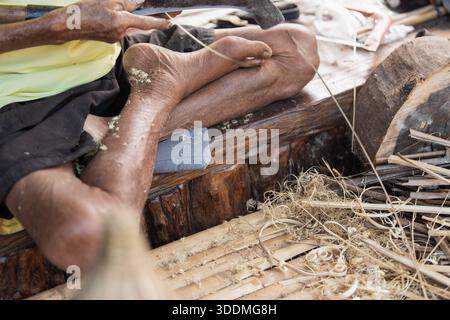 Espace de travail artisanal avec des outils traditionnels et des déchets d'artisanat en bambou Banque D'Images