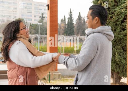 Couple asiatique se tenant la main lors d'une réunion pour une date dans le parc le jour de la Saint-Valentin Banque D'Images